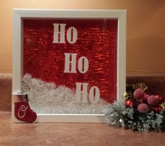 a red and white frame sitting on top of a counter next to a christmas decoration