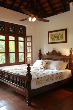 a large bed sitting in the middle of a bedroom next to two wooden framed windows