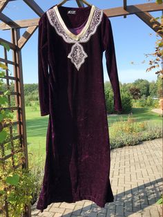 Beautiful purple Arabic kaftan dress with embroidered gold sequin details on the chest. The dress falls beautifully, is long enough and has slits at the bottom of the sides. The material has some stretch and shine. Material: no label, but it's velvet. Size: Label size M - Medium, EU 38, UK 10.  Check the measurements below: MEASUREMENTS: Shoulder 46.5 cm - 18.31 inches Armpit to armpit 49.5 cm - 19.49 inches Waist 44.5 cm - 17.52 inches Sleeve length from shoulder 58 cm - 22.83" Total length 134 Elegant Dresses With Embroidered Neckline For Festivals, Elegant Embroidered Neckline Dress For Festivals, Festive Embroidered V-neck Thobe, Long Sleeve Dress With Embroidered Border For Festivals, Bollywood Style Long Sleeve Festival Dress, Long Sleeve Bollywood Dress For Festival, Long Dresses With Gold Embroidery For Eid, Bollywood Style Embellished Tunic Dress, Festive Long Sleeve Dress With Embroidered Border