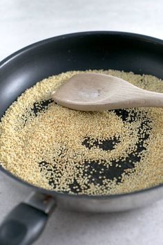 a wooden spoon in a pan filled with grains