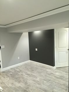 an empty living room with gray walls and wood floors