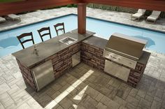 an outdoor kitchen next to a swimming pool with chairs and grills on the patio