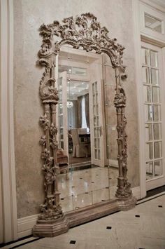 an ornate mirror in the middle of a room