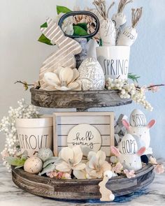 three tiered trays with easter decorations on top of each other, including eggs and flowers