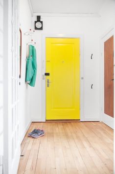 a bright yellow door in a white room