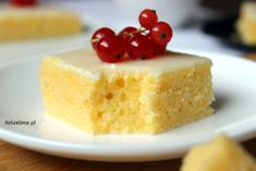 a piece of cake on a white plate with some cherries on top of it