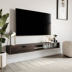 a flat screen tv mounted to the side of a wall in a living room with white walls