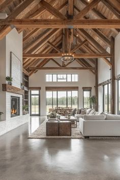 a large open living room with high ceilings and wooden beams on the ceiling, along with white couches