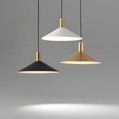 three pendant lights hanging from the ceiling in different colors and shapes, one black, one white