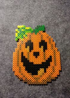 a perler bead pumpkin with a smile on it's face is shown