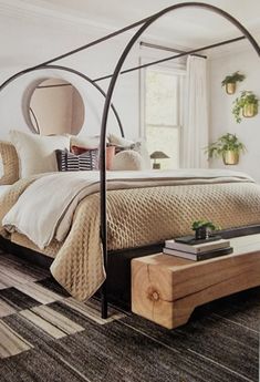 a bedroom with a canopy bed and rugs on the floor in front of it