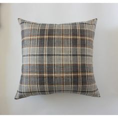 a gray plaid pillow sitting on top of a white wall