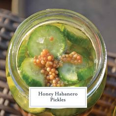 a jar filled with sliced cucumbers and chickpeas on top of a table