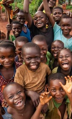 a group of young children standing next to each other with their hands in the air