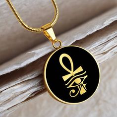 "This Ankh Necklace Is the Perfect Gift for all those Travel lovers, Whether for Yourself or a Loved One.  ➜ Our jewelry is made of high-quality surgical steel with a shatterproof liquid glass coating and an 18k gold finish option. ➜ Engrave onto the back of the Egyptian pendant your loved one's name, your wedding date, an anniversary, or anything else you want to remember and keep you close to her heart. You can add 2 lines and each up to 20 characters long. Each personalized Eye of Ra pendant offers exceptional craftsmanship that is fit to be an instant classic in your family. ➜ If you're not 100% satisfied with your purchase for any reason, please contact us and we will make it right. Your satisfaction is our ultimate goal. Explore all our Symbolic gifts here: https://www.etsy.com/shop/ Spiritual Stainless Steel Jewelry Round Shape, Spiritual Stainless Steel Jewelry, Black Stainless Steel Medallion Necklaces, Black Medallion Stainless Steel Necklaces, Black Stainless Steel Medallion Necklace, Symbolic Stainless Steel Medallion Jewelry, Symbolic Tarnish Resistant Stainless Steel Necklaces, Symbolic Tarnish Resistant Stainless Steel Necklace, Symbolic Stainless Steel Tarnish Resistant Necklace