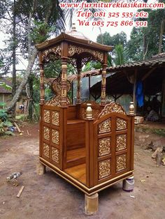 an ornate wooden bed in the middle of some dirt