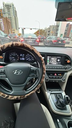 the interior of a car with dashboard and steering wheel controls in front of other cars