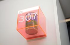 an orange and pink display case with a canned drink in the bottom right hand corner