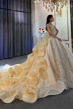 a woman in a wedding dress standing next to a chandelier