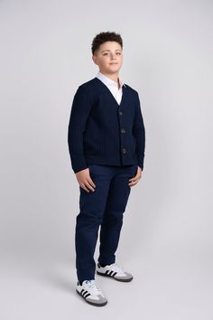 Introducing our Navy Chunky Knit Cardigan – the perfect blend of style, warmth, and comfort for your young trendsetter. The rich navy hue complements any outfit, making it a versatile addition to his wardrobe for both casual and semi-formal occasions. Featuring a classic design, this cardigan is adorned with large brown buttons that not only serve as functional closures but also add a charming contrast to the deep navy fabric. Navy Cotton Cardigan For Winter, Navy Cotton Winter Cardigan, Navy Cotton Cardigan For Fall, Navy Cotton Cardigan For Work, Casual Navy Cardigan For Fall, Navy Long Sleeve Cotton Cardigan, Navy Sweater For Layering In Fall, Navy Sweater For Fall Layering, Navy Long Sleeve Cardigan For Work