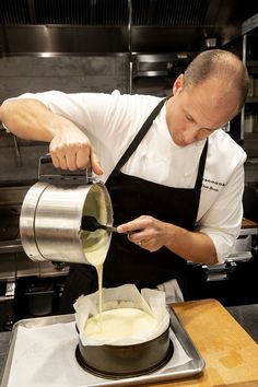 a man pouring batter into a pan on top of a stove