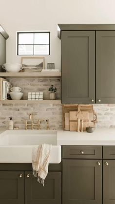 a kitchen with gray cabinets and white counter tops