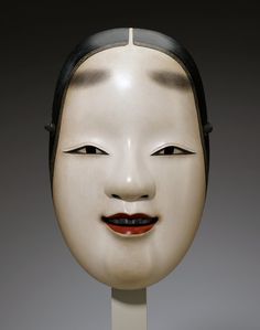 a white mask with black hair and red lips