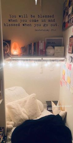 there is a small bed with lights on the headboard and bookshelf behind it