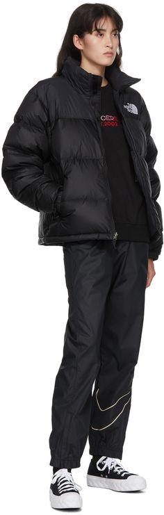 Long sleeve down-filled quilted wind and water-resistant nylon ripstop jacket in black. Cord-lock drawstring and Velcro fastening at stow-away hood. Stand collar. Zip closure at front. Logo embroidered in white at chest and back. Zippered pockets at waist featuring concealed integrated stow-away pocket. Concealed drawstring with cord-lock fastening at hem. Press-stud and Velcro fastenings at partially elasticized cuffs. Zippered pocket at interior. Fully lined. Tonal and gunmetal-tone hardware. North Face Clothing, 1996 Retro Nuptse Jacket, North Face Outfits, Retro Nuptse Jacket, Nuptse Jacket, Black North Face, Press Studs, Logo Embroidered, Luxury Streetwear