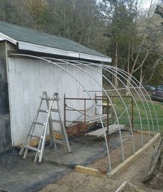 a small white shed with a ladder next to it