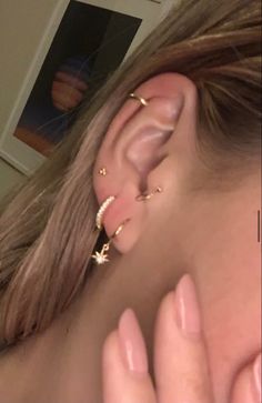 a woman wearing gold ear piercings with stars on them