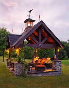 a gazebo in the middle of a grassy area with lights on it's roof