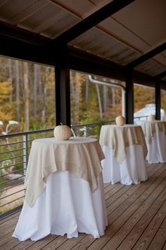 tables with white tablecloths and pumpkins on them