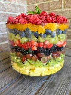 a large glass bowl filled with fruit on top of a wooden table