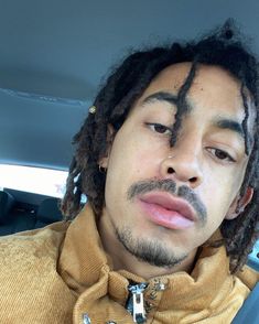 a man with dreadlocks sitting in a car