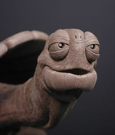 a close up of a clay sculpture of a frog with eyes open and mouth wide open