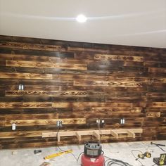 a room that has some wood planks on the wall and tools in front of it