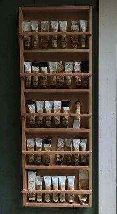 a wooden shelf filled with lots of different types of coffee beans and bags on top of it