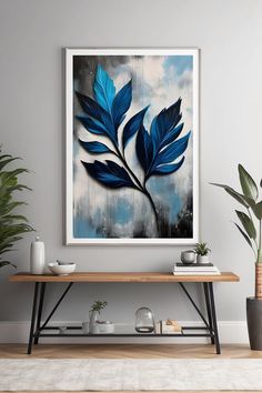 a painting hanging on the wall next to a table with potted plants in it