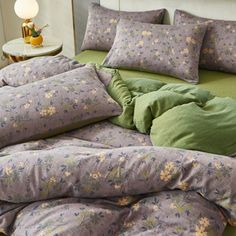 the comforter is made up with green and purple sheets, pillows, and blankets