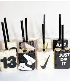 there are four cakes that have numbers on them and black sticks sticking out of them