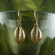 These beautiful cowrie shell earrings were cast from shells that we found on a beach in Asia, and by sanding down the back of the shell, we revealed the beautiful natural spiral inside.  These have long been a female symbol of fertility and strength - time to unleash your inner Barbarella.Perfect little size, 16mm high by 10mm wide.  Hung on our home made Lost Apostle earring hooks.  Cast in the finest bronze, these really are lovely.  They are hypo allergenic, so no problems for those of you wi Elegant Spiral Beach Jewelry, Shell-shaped Brass Jewelry For The Beach, Gold Cowrie Shell Earrings For Gift, Gold Cowrie Shell Earrings As Gift, Beach Shell Brass Jewelry, Brass Shell Jewelry For Beach, Natural Cowrie Shell Jewelry As Gift, Natural Color Cowrie Shell Jewelry Gift, Natural Cowrie Shell Jewelry For Gift