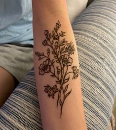 a woman's arm with a tattoo on it that has flowers in the middle