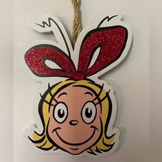 Cover Your Christmas In Smiling Faces Straight From The Imagination Of Dr. Seuss! It's Easy To Get Started With This New Grinch Cindy Lou Who Ornament. This Ornament Is Shaped Like Cindy Lou Who's Face With A Red Glitter Bow. Use The Twisted Rope At The Top To Hang It By The Highest Branch! Details: Length: 4 3/4" Width: 3 1/2" Thickness: 1/8" Cindy Lou Who Ornament, Grinch Cindy Lou, Grinch Ornament, Heart Christmas Ornaments, Grinch Face, Grinch Ornaments, Rudolph Christmas, Cindy Lou Who, Homemade Ornaments