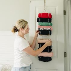 a woman hanging folded towels on a wall