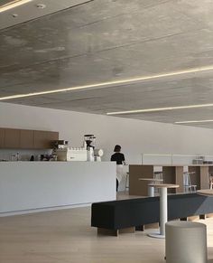 an empty office with people working at the counter and on the other side of the room