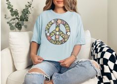 "Embrace the free-spirited essence of bohemian style with our flowered peace t-shirt. Crafted with soft, breathable fabric, this shirt features a vibrant floral design intertwined with symbols of peace, creating a harmonious blend of nature and tranquility. Whether you're strolling through a festival or simply seeking laid-back comfort, this t-shirt effortlessly exudes boho-chic charm while spreading messages of love and unity. Flaunt your individuality with every wear and let your inner flower child bloom with pride. Comfort Colors introduces the \"Comfort Colors 1717\" garment-dyed t-shirt, a tee made 100% with ring-spun cotton. The soft-washed, garment-dyed fabric brings extra coziness to your wardrobe while the relaxed fit makes it an excellent daily choice. The double-needle stitching Peace T Shirt, Hippie T Shirt, Festival T Shirts, Hippie Shirt, Free Spirited, Boho Stil, Flower Child, Peace Sign, Unique Tshirts