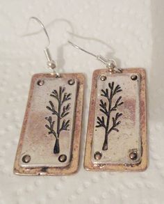 These silver plated (treated to deter tarnish) 3-D earrings are approximately 1 1/4 inch in length and 5/8 inch wide.  They are backed with gold plate, in the style of slightly distressed and the back of these earrings are plain.  All earrings have sterling silver (.925) fishhook fasteners and all fishhooks come with a clear, rubber earring back. Stamped Metal Earrings For Gifts, Nickel-free Rectangular Metal Earrings, Earring Backs, Fish Hook, Silver 925, Jewelry Earrings Dangle, Silver Earrings, Silver Plate, 3 D