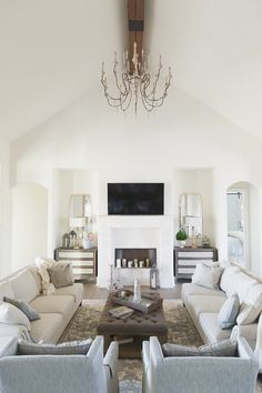 a living room filled with furniture and a flat screen tv mounted on the wall above a fireplace