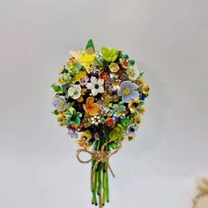 a bouquet of flowers with lots of different colored glass beads on it's stems